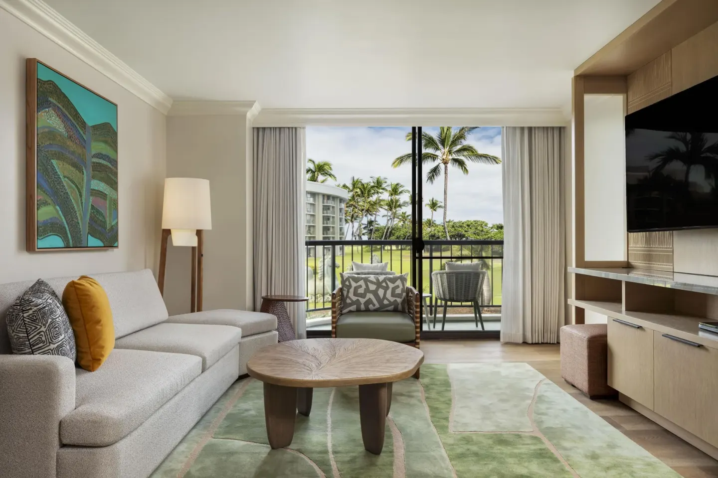 Suite living room with balcony and resort view at Hilton Waikoloa Village.