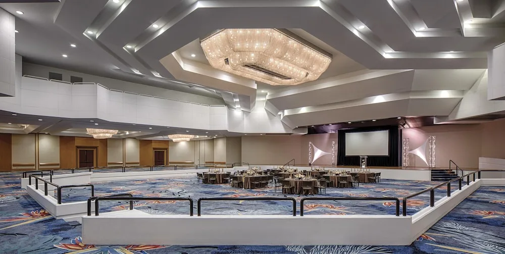 Wide ballroom with banquet tables and chandeliers at Hilton Waikoloa Village.