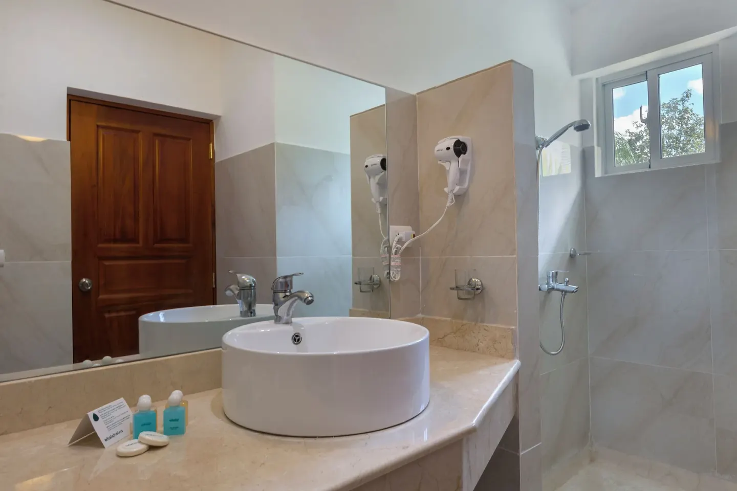 Bathroom vanity with round sink, mirror and walk-in shower at HM Alma de Bayahibe.
