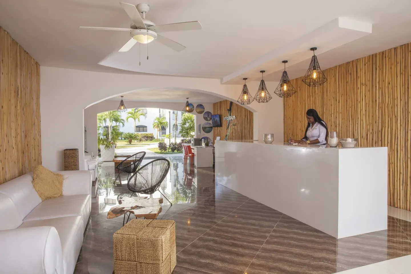 Bright lobby reception with white desk and wood accent walls at HM Alma de Bayahibe.