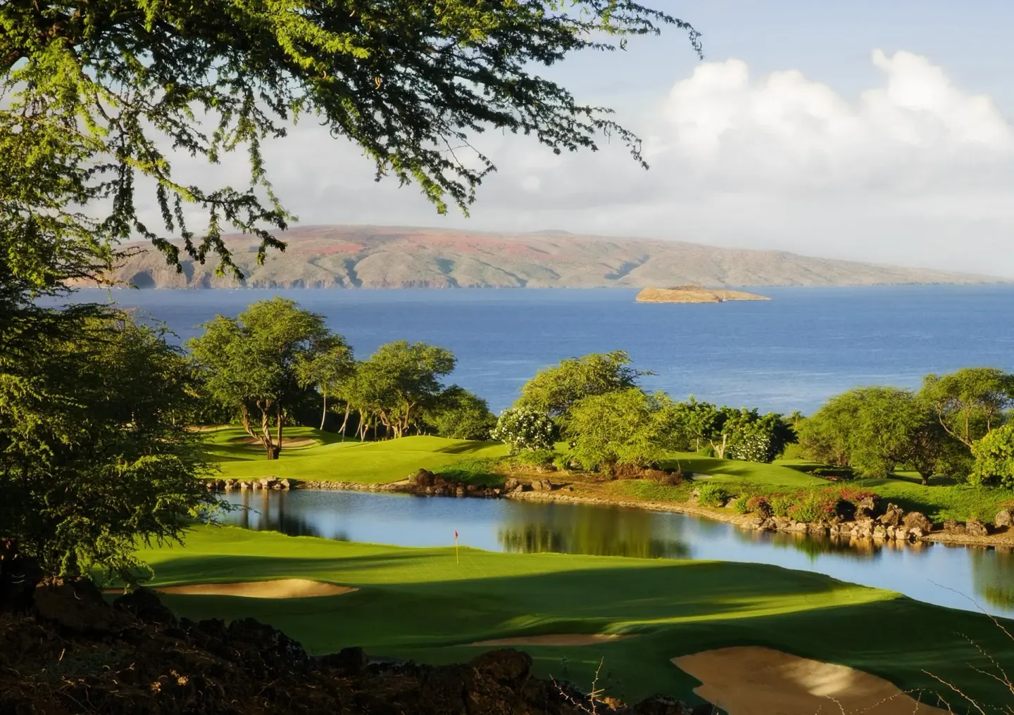 Coastal golf course with pond and ocean beyond at Ho‘olei Villas at Grand Wailea.
