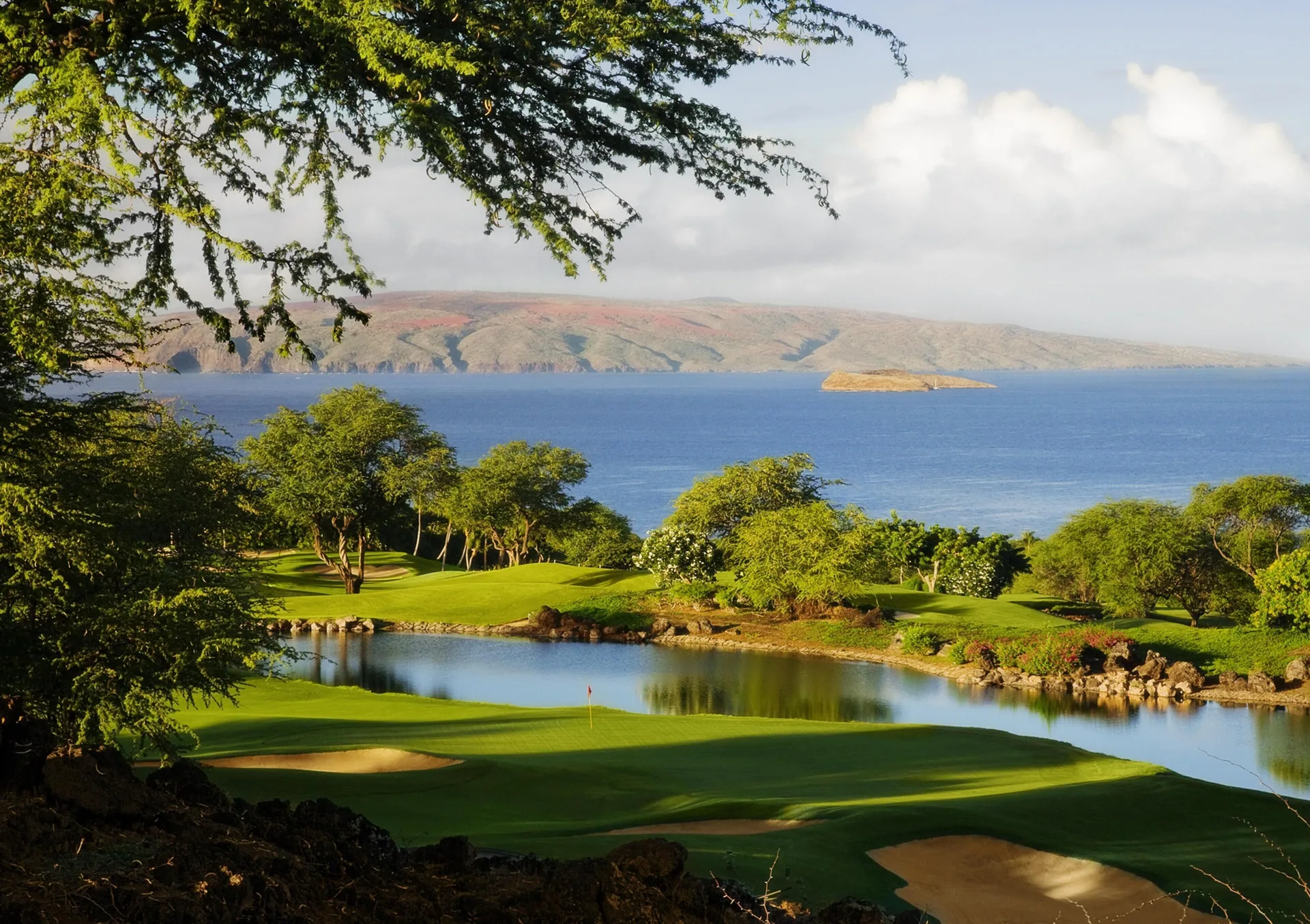 Coastal golf course with pond and ocean beyond at Ho‘olei Villas at Grand Wailea.