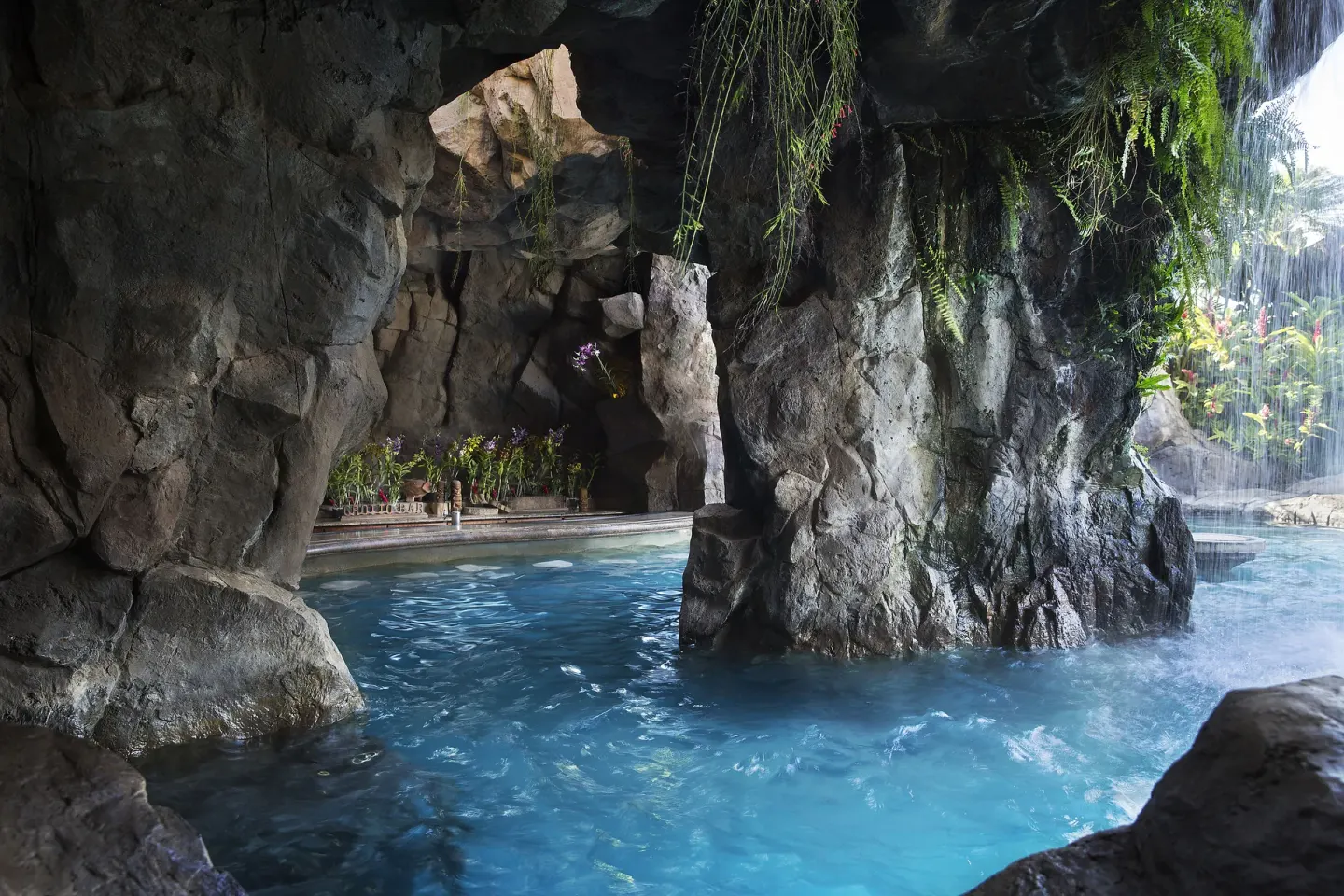 Grotto pool area with rock walls and hanging plants at Ho‘olei Villas at Grand Wailea.