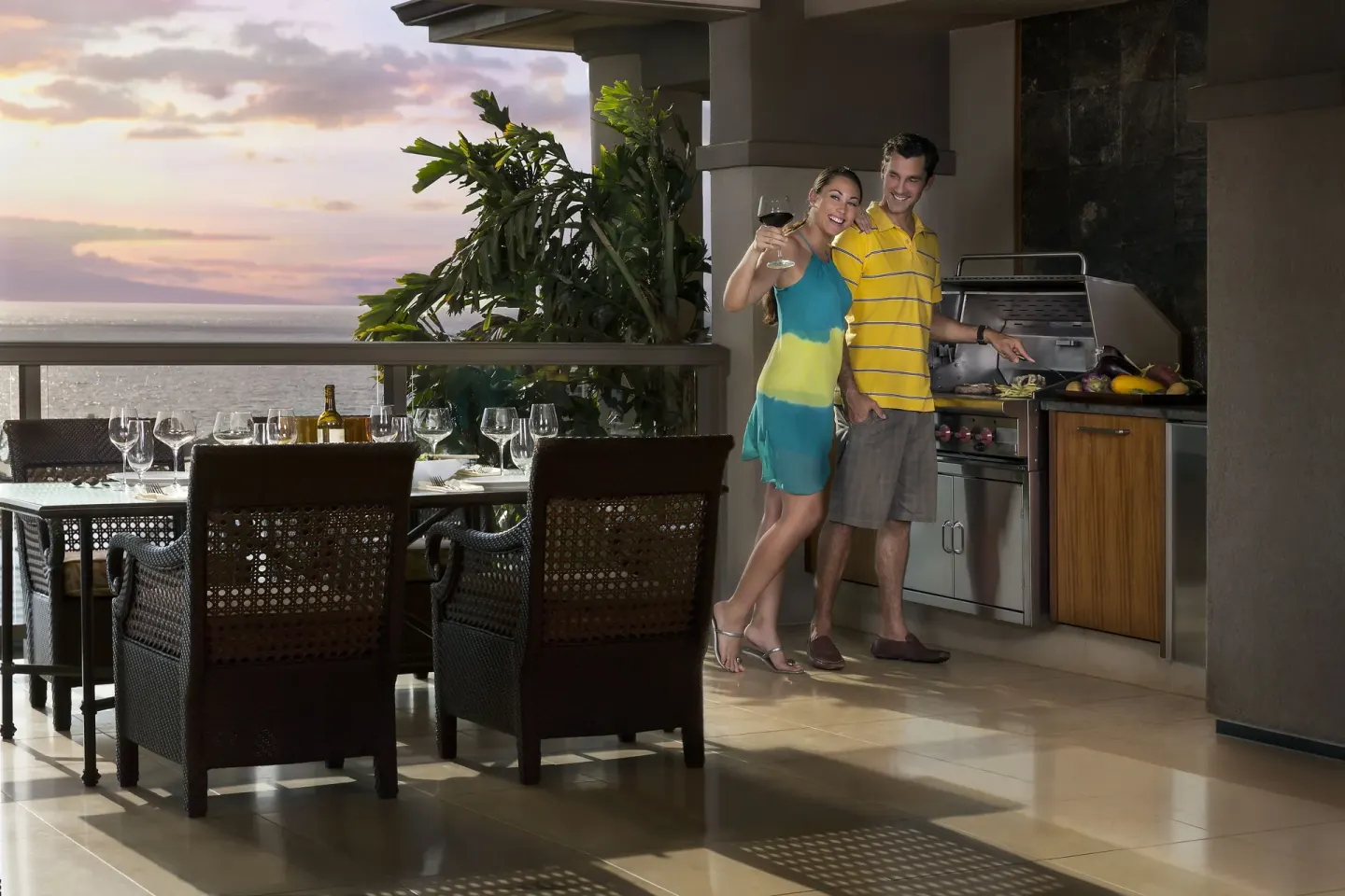 Couple on an ocean-view lanai with grill and dining table at Ho‘olei Villas at Grand Wailea.