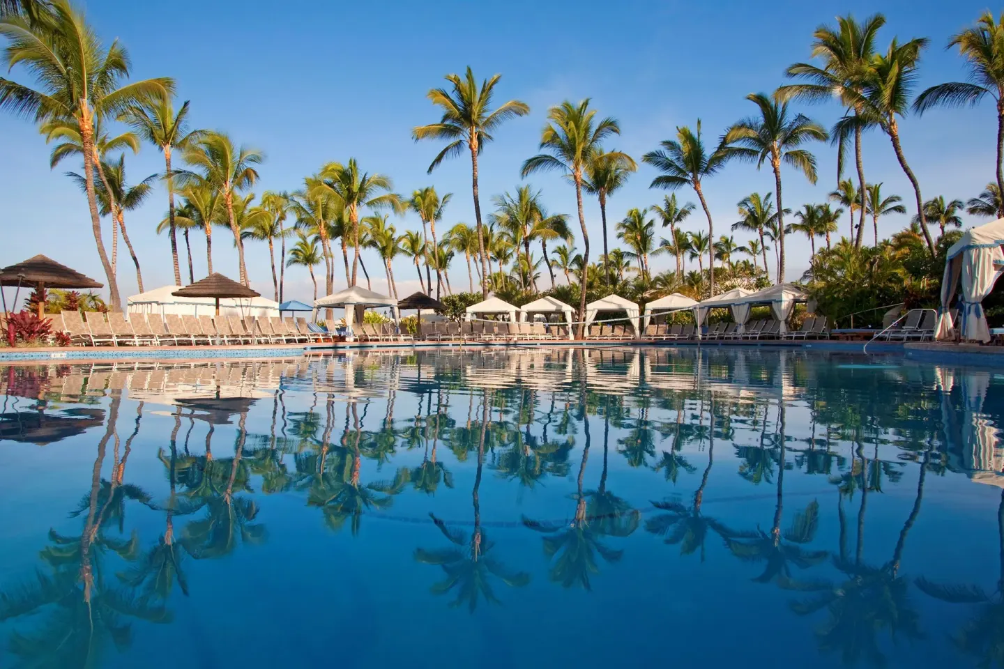 Palm-lined resort pool with cabanas and reflections at Ho‘olei Villas at Grand Wailea.