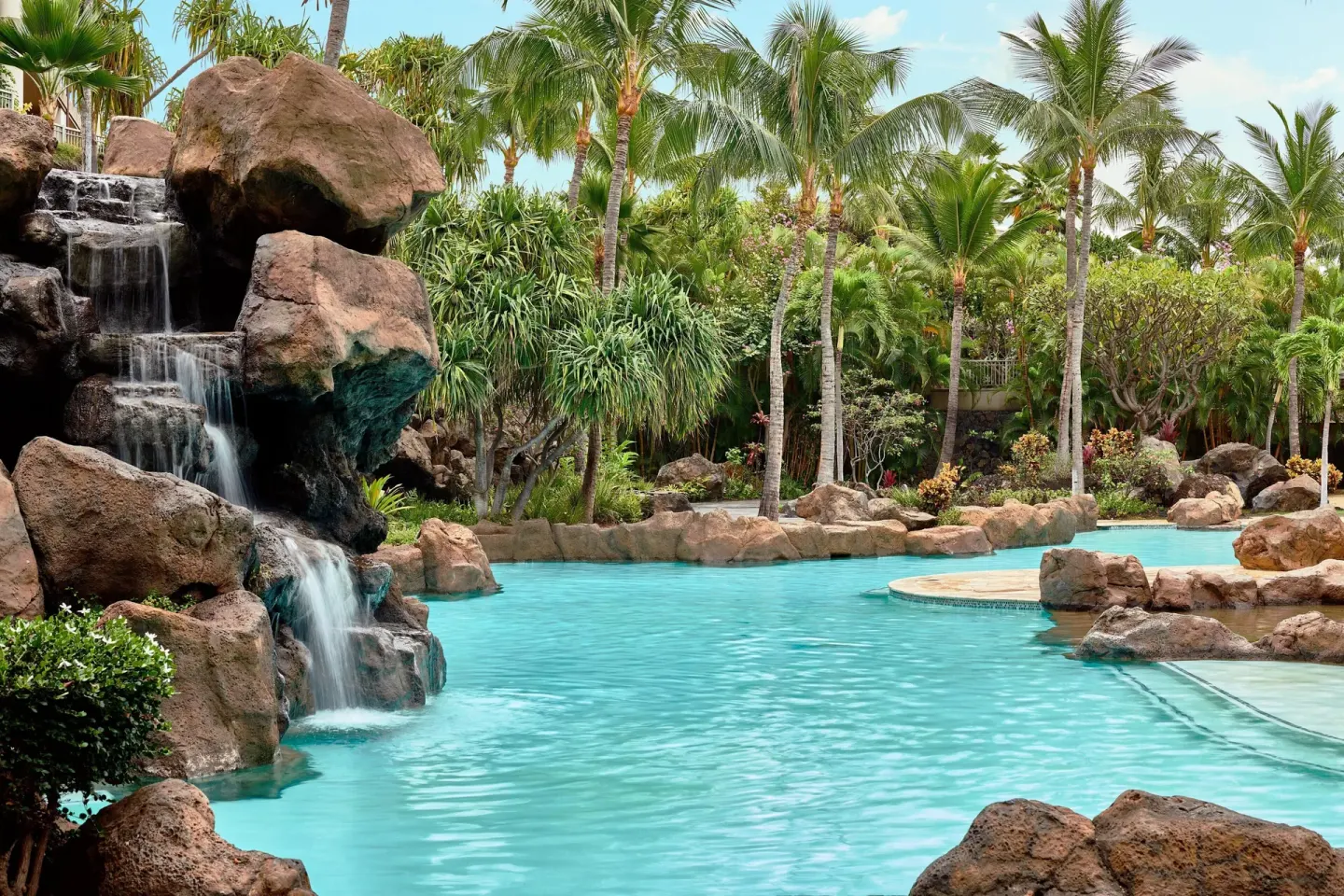 Rock waterfall flowing into a tropical pool at Ho‘olei Villas at Grand Wailea.