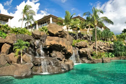 Rock waterfalls flowing into a turquoise pool at Ho‘olei Villas at Grand Wailea.
