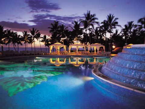 Twilight pool with cabanas and palm silhouettes at Ho‘olei Villas at Grand Wailea.