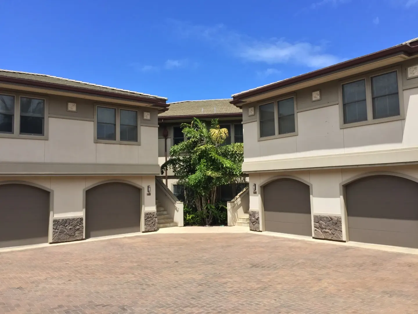 Villa garages and entry stairs at Ho‘olei Villas at Grand Wailea under a blue sky.