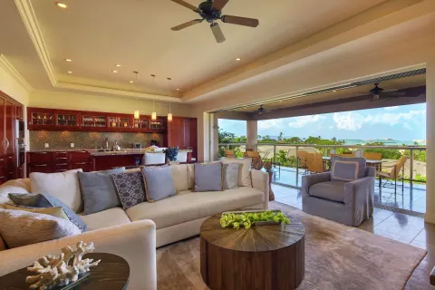 Spacious villa living room with kitchen and lanai at Ho‘olei Villas at Grand Wailea.