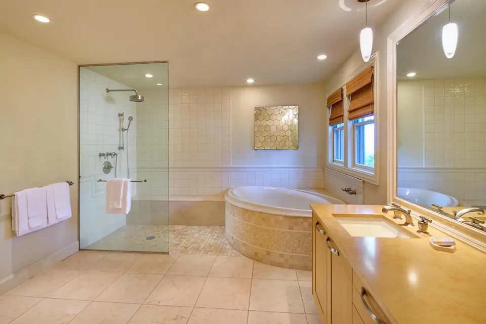 Villa bathroom with soaking tub, glass shower, and vanity at Ho‘olei Villas at Grand Wailea.