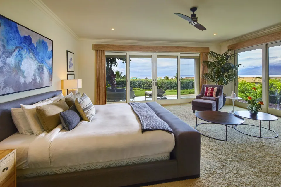Luxury villa king bedroom with sitting area and ocean-view doors at Ho‘olei Villas at Grand Wailea.