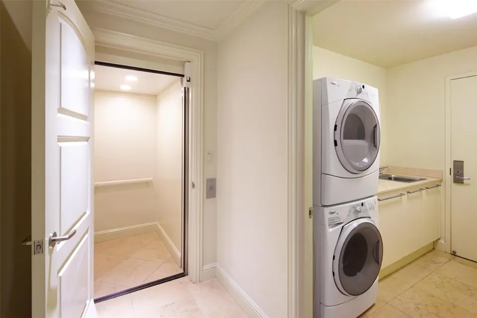 Luxury villa laundry area with stacked machines and nearby closet at Ho‘olei Villas at Grand Wailea.