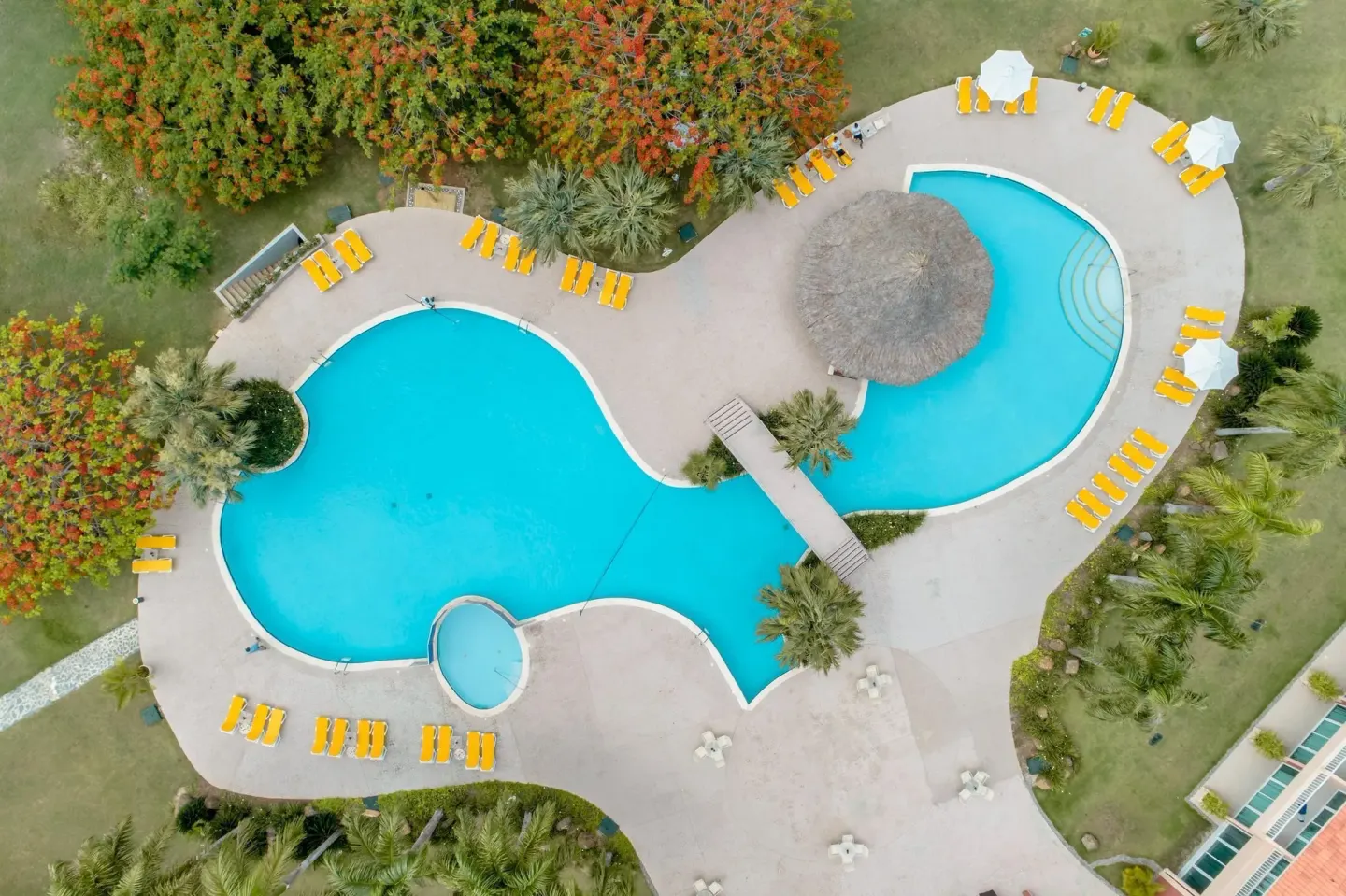 Aerial view of linked resort pools at Hodelpa Garden Suites Golf & Convention Center.