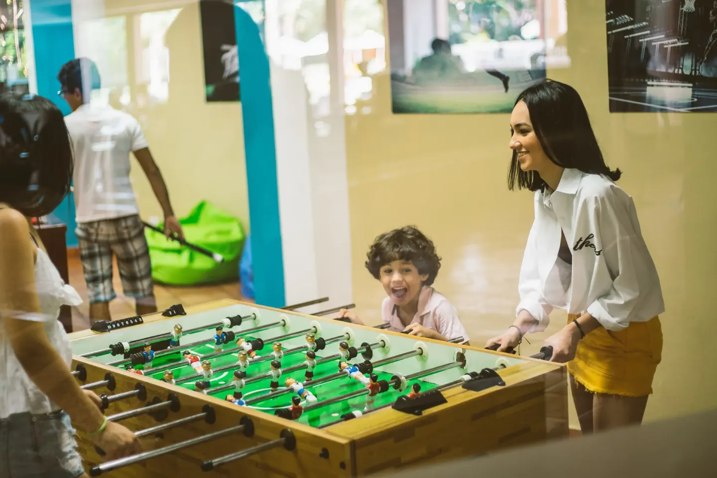 Guests play foosball in the game room at Hodelpa Garden Suites Golf & Convention Center.