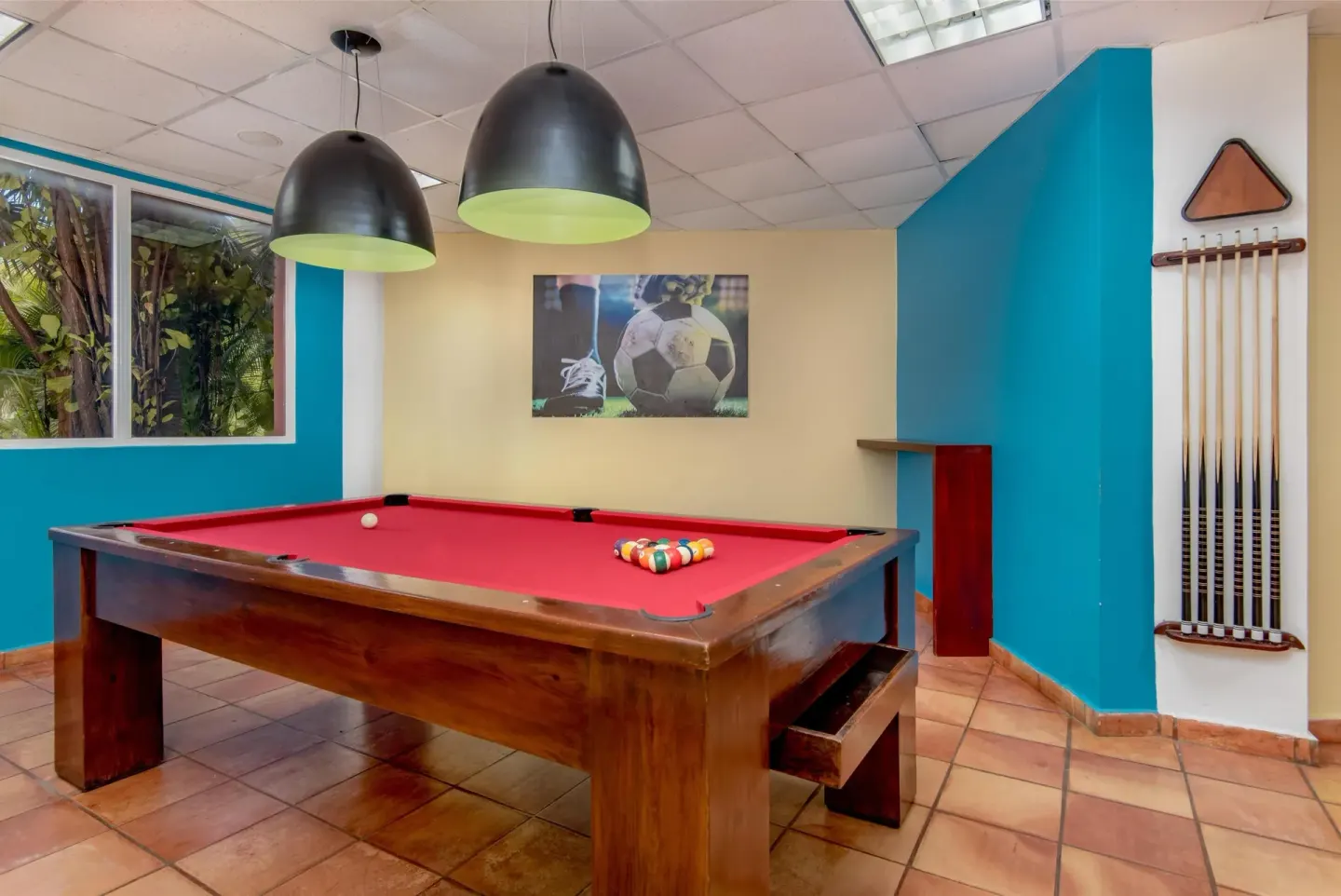 Red-felt billiards table in the game room at Hodelpa Garden Suites Golf & Convention Center.