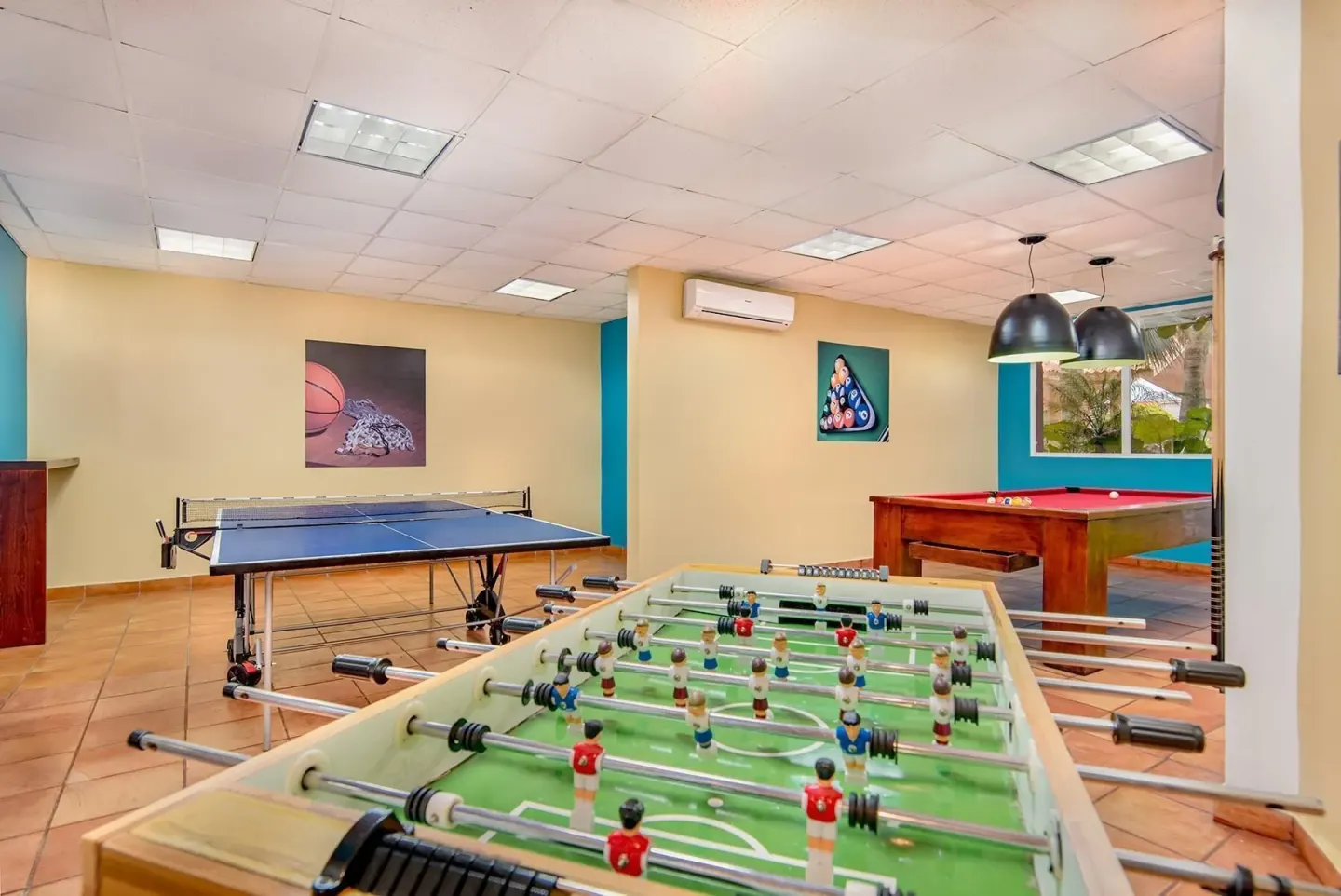 Game room with foosball, table tennis, and billiards at Hodelpa Garden Suites Golf & Convention Center.