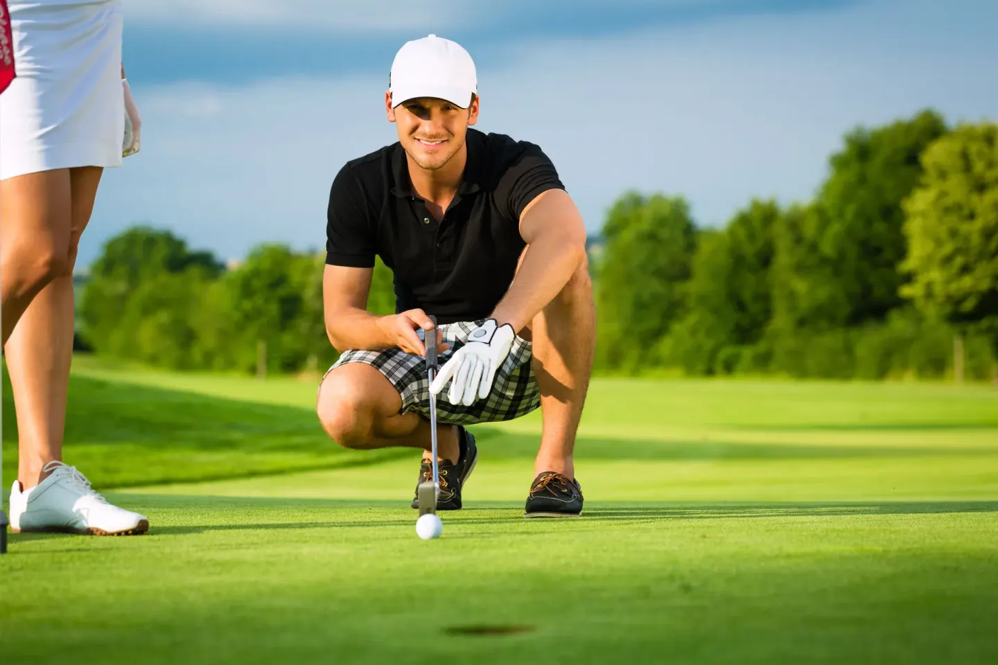 A golfer lines up a putt on the green at Hodelpa Garden Suites Golf & Convention Center.
