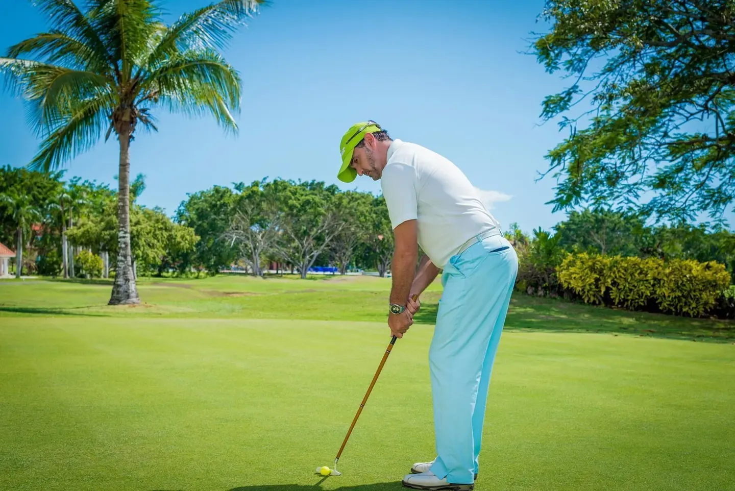 Golfer putts on a green at Hodelpa Garden Suites Golf & Convention Center.