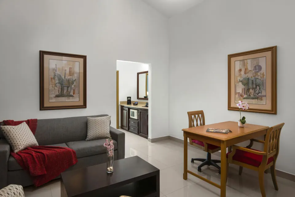 Royal Suite living room and dining table at Hodelpa Garden Suites Golf & Convention Center.