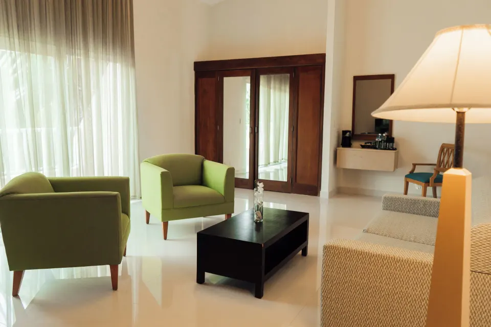 Royal Suite lounge with green armchairs at Hodelpa Garden Suites Golf & Convention Center.
