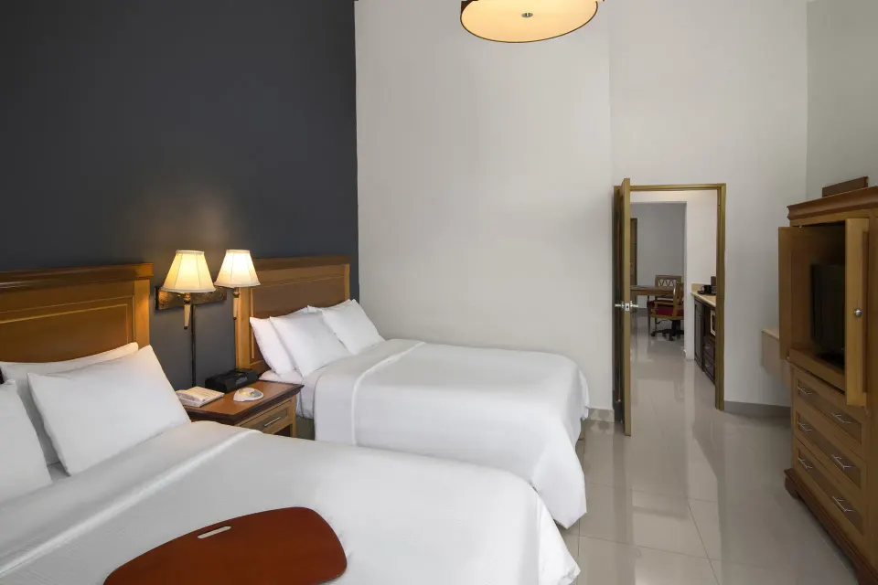 Royal Suite bedroom with two beds at Hodelpa Garden Suites Golf & Convention Center.