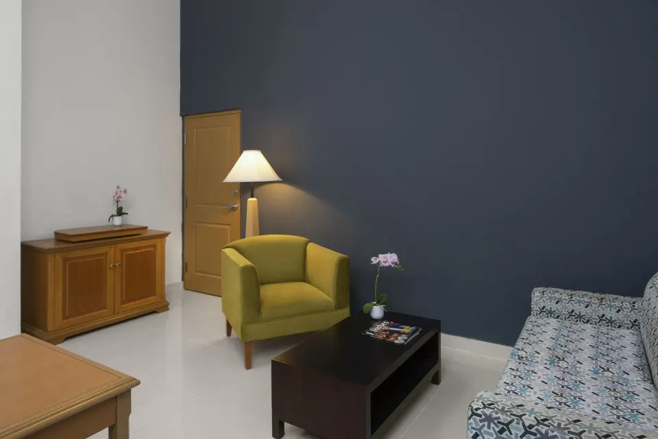 Suite sitting area with sofa, armchair, and coffee table at Hodelpa Garden Suites Golf & Convention Center.