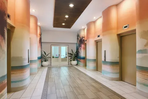 Elevator lobby with beach-themed wall murals at Holiday Inn Express Waikiki.
