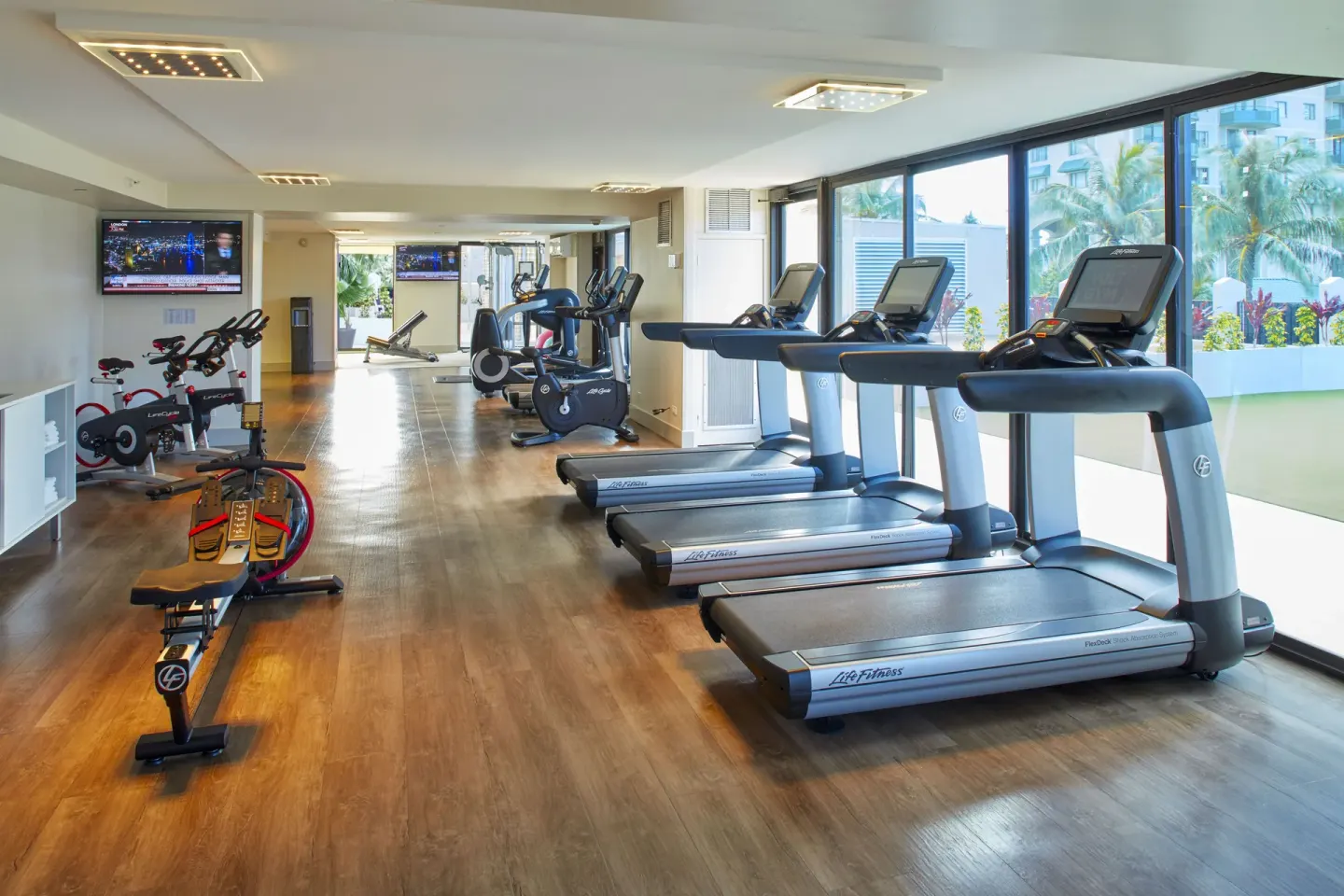 Fitness room with treadmills, bikes, and large windows at Holiday Inn Express Waikiki.