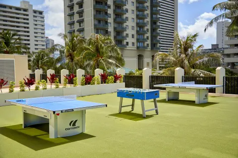 Outdoor game area with table tennis and foosball at Holiday Inn Express Waikiki.
