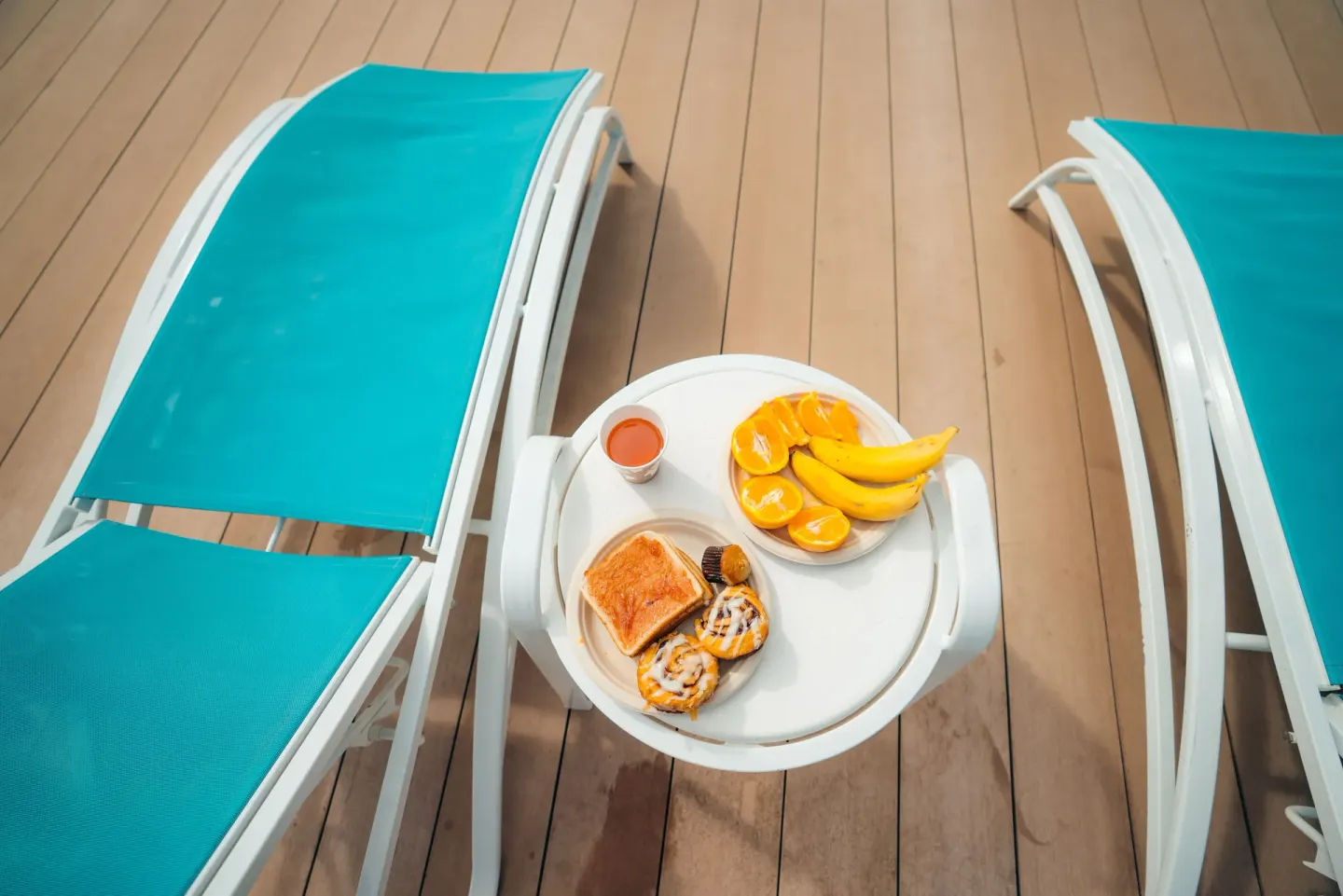 Poolside loungers with breakfast plates on a small table at Holiday Inn Express Waikiki.
