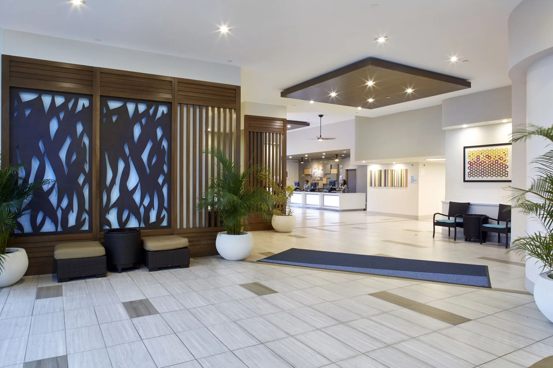 Spacious lobby with decorative screens, plants, seating, and front desk at Holiday Inn Express Waikiki.