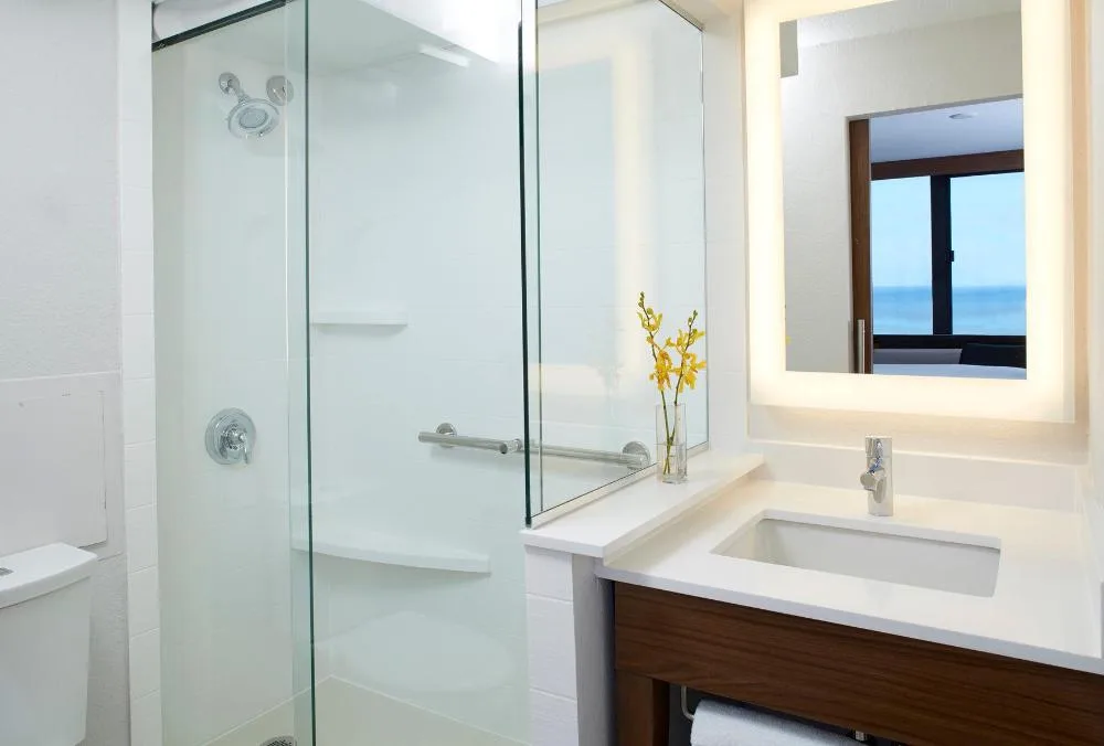Accessible bathroom with glass shower and vanity at Holiday Inn Express Waikiki.