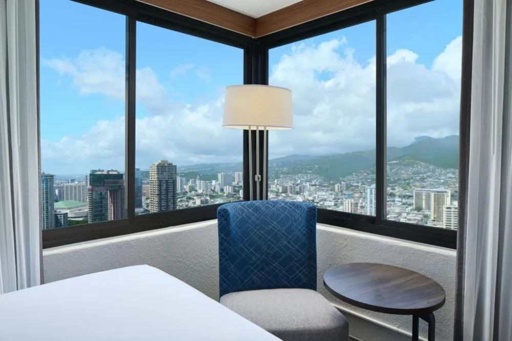 Standard accessible Waikiki view room seating by corner windows at Holiday Inn Express Waikiki.