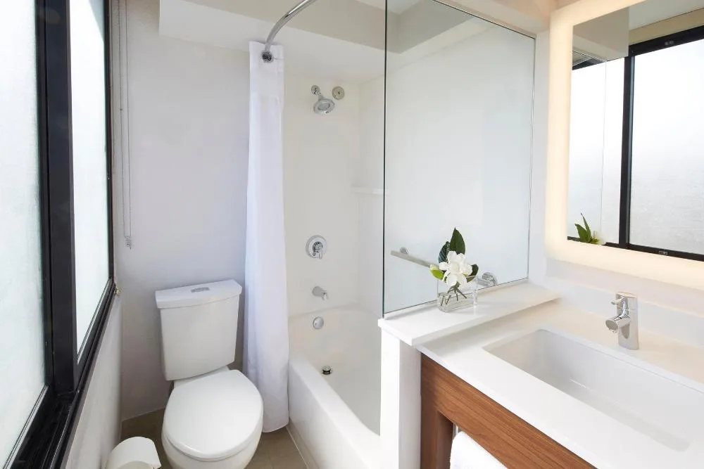 Accessible bathroom with tub and vanity at Holiday Inn Express Waikiki.