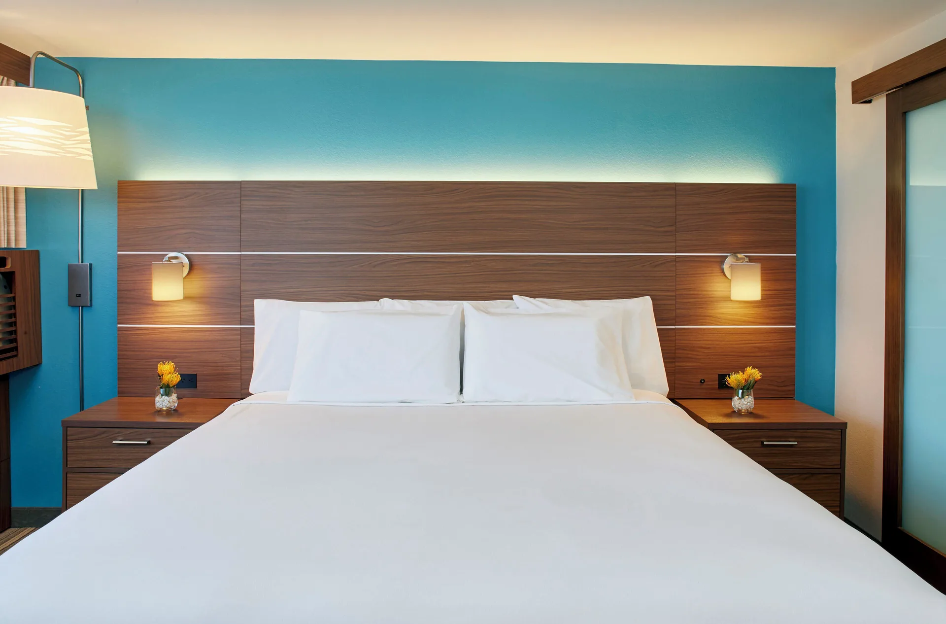 Standard Room king bed with turquoise accent wall at Holiday Inn Express Waikiki.