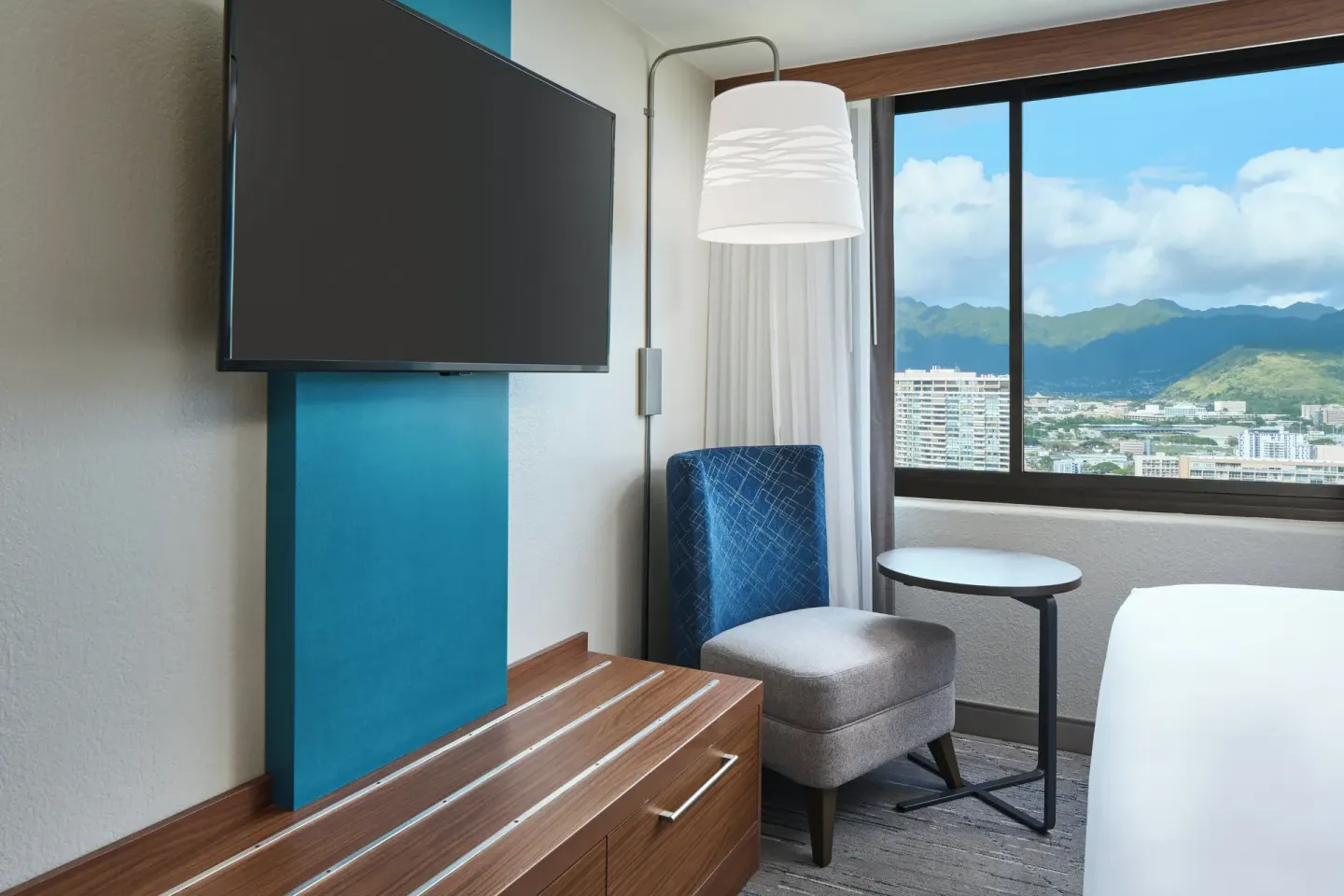 Standard Room seating corner with TV, chair, table, and mountain view at Holiday Inn Express Waikiki.