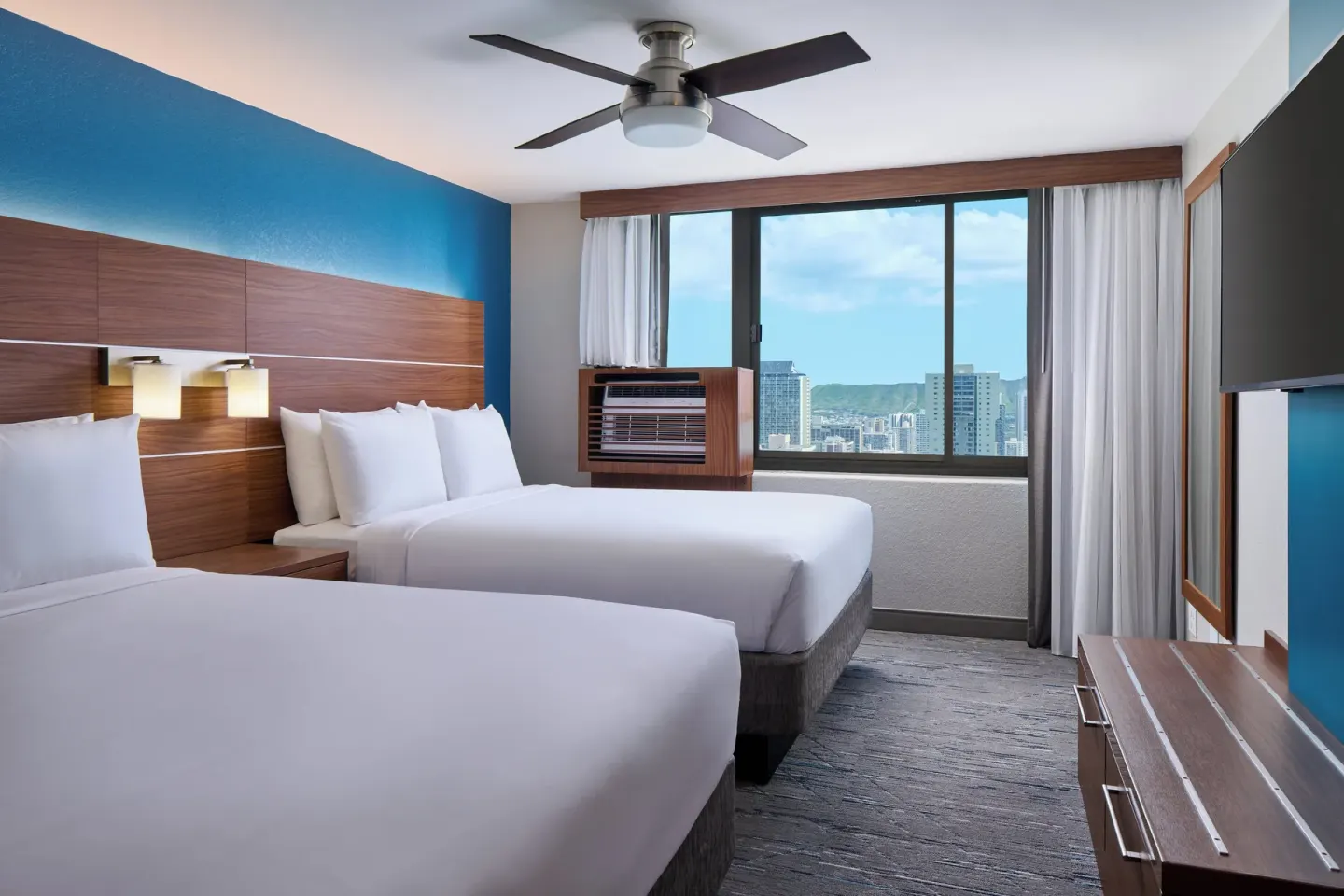 Standard Room two beds with large window, TV, and city view at Holiday Inn Express Waikiki.