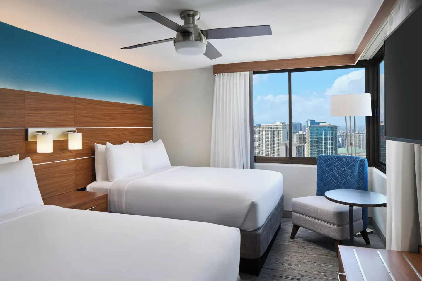 Standard Room two beds with corner windows and seating area at Holiday Inn Express Waikiki.