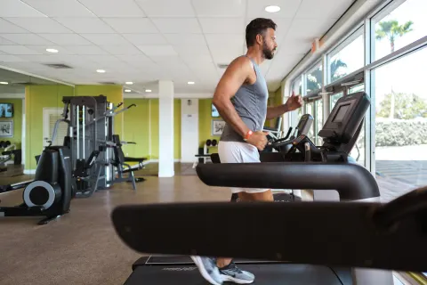 Man running on a treadmill in the fitness room at Holiday Inn Resort Aruba - Beach Resort & Casino.