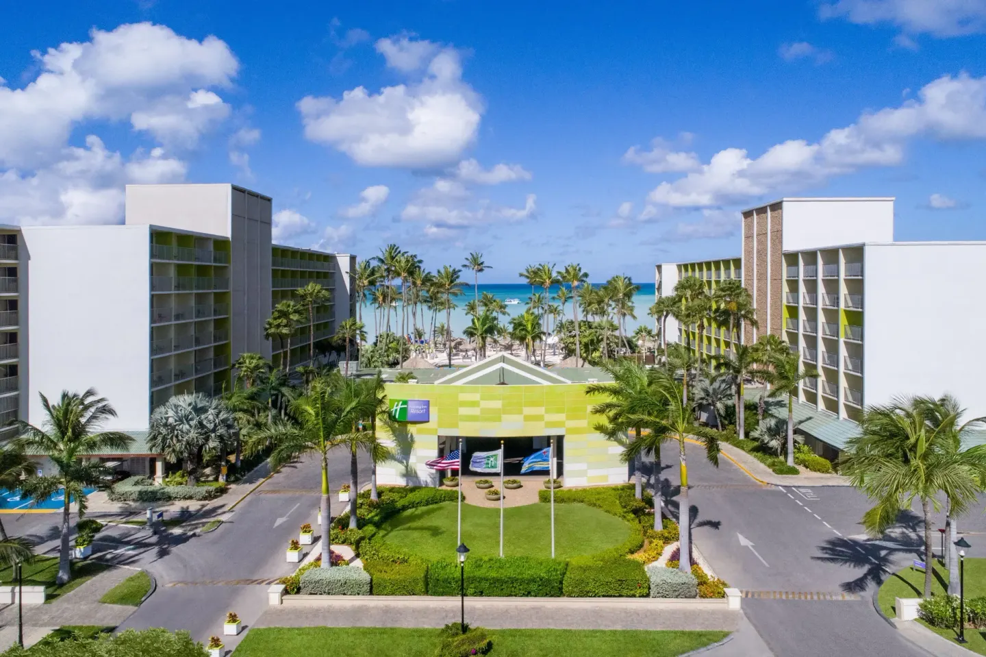 Resort entrance and buildings facing the ocean at Holiday Inn Resort Aruba - Beach Resort & Casino.