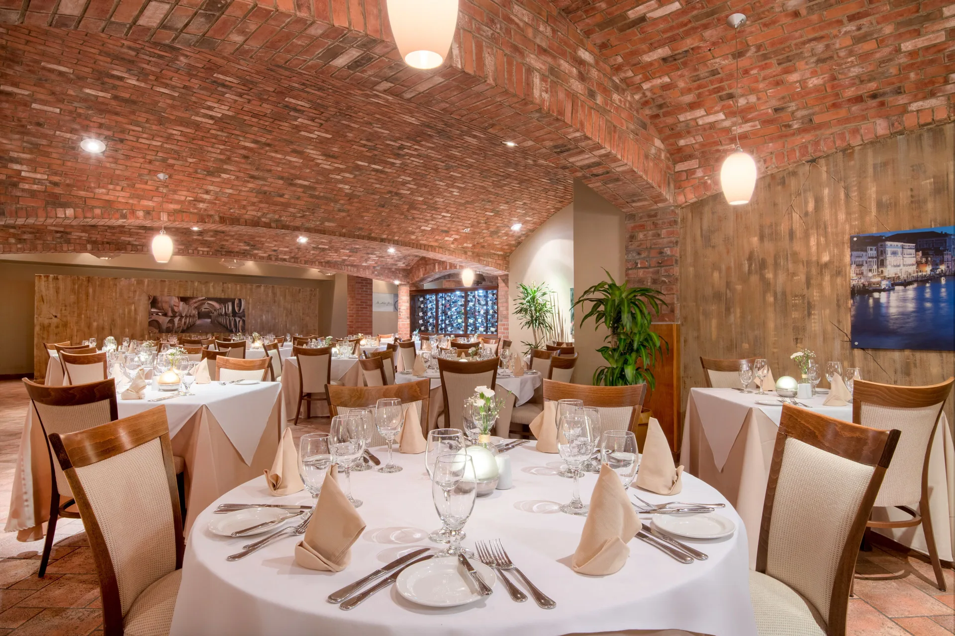 Brick-ceiling dining room set with round tables at Holiday Inn Resort Aruba - Beach Resort & Casino.