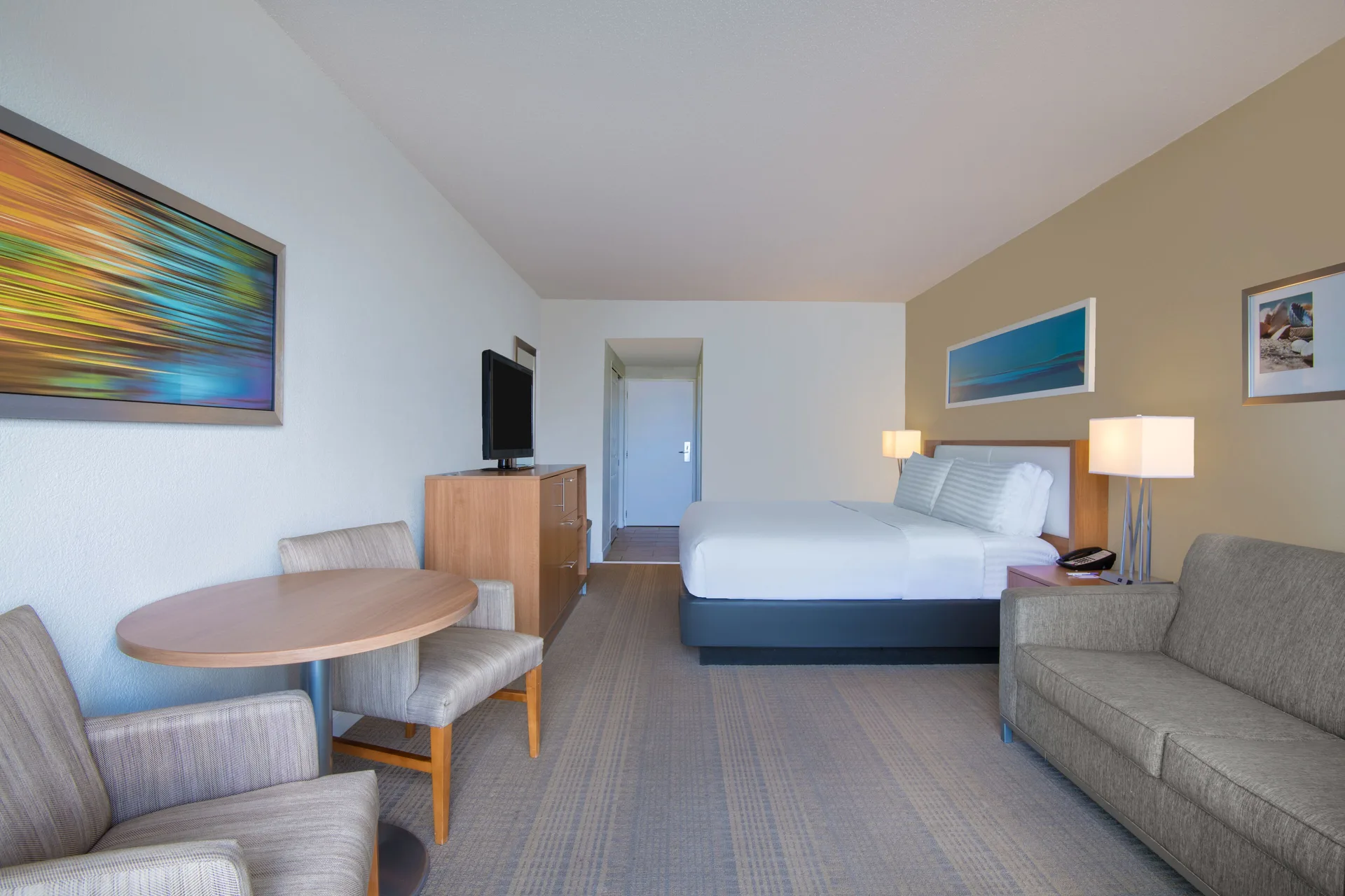 Premium Room king bed with sofa and table at Holiday Inn Resort Aruba - Beach Resort & Casino.
