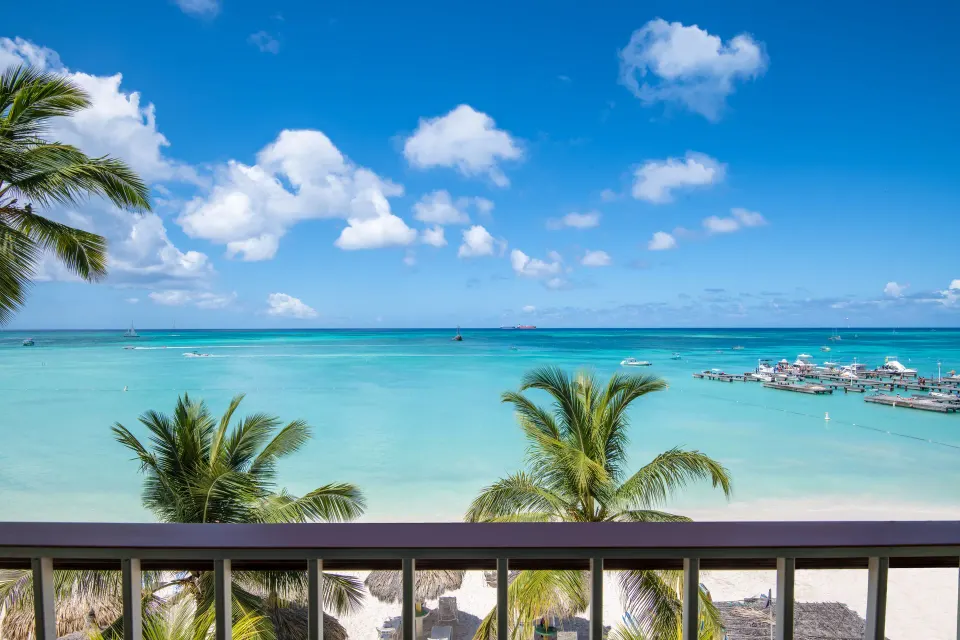 Oceanfront balcony view from Holiday Inn Resort Aruba - Beach Resort & Casino toward turquoise water.