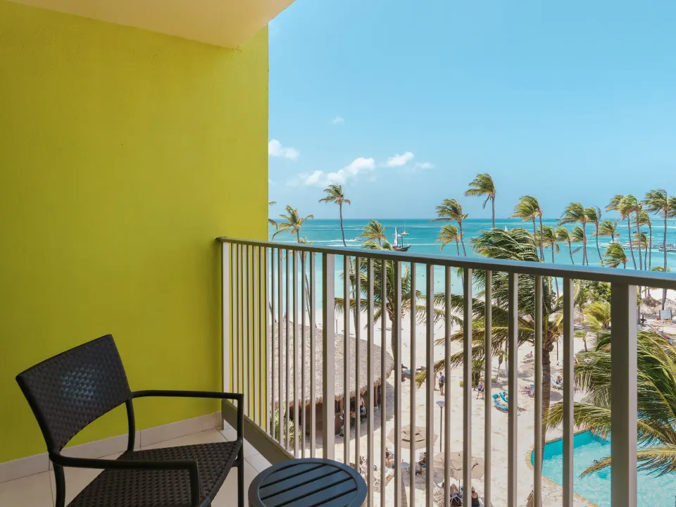 Partial ocean view balcony with chairs at Holiday Inn Resort Aruba - Beach Resort & Casino.