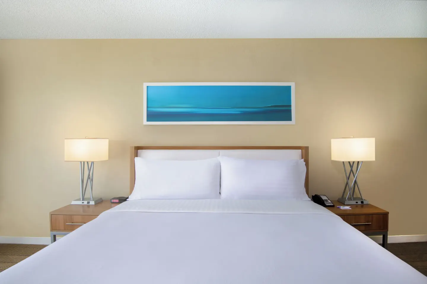 King bed with bedside lamps in a Standard Room Resort View at Holiday Inn Resort Aruba - Beach Resort & Casino.