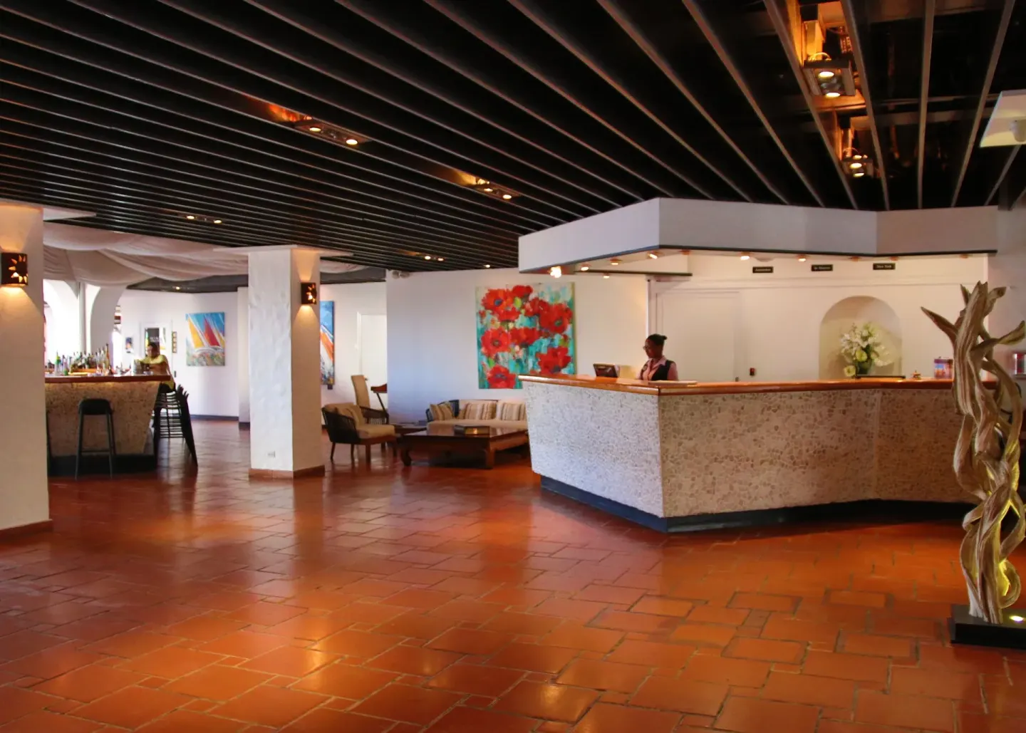 Lobby reception area with terracotta floors and lounge seating at Holland House Beach Hotel.