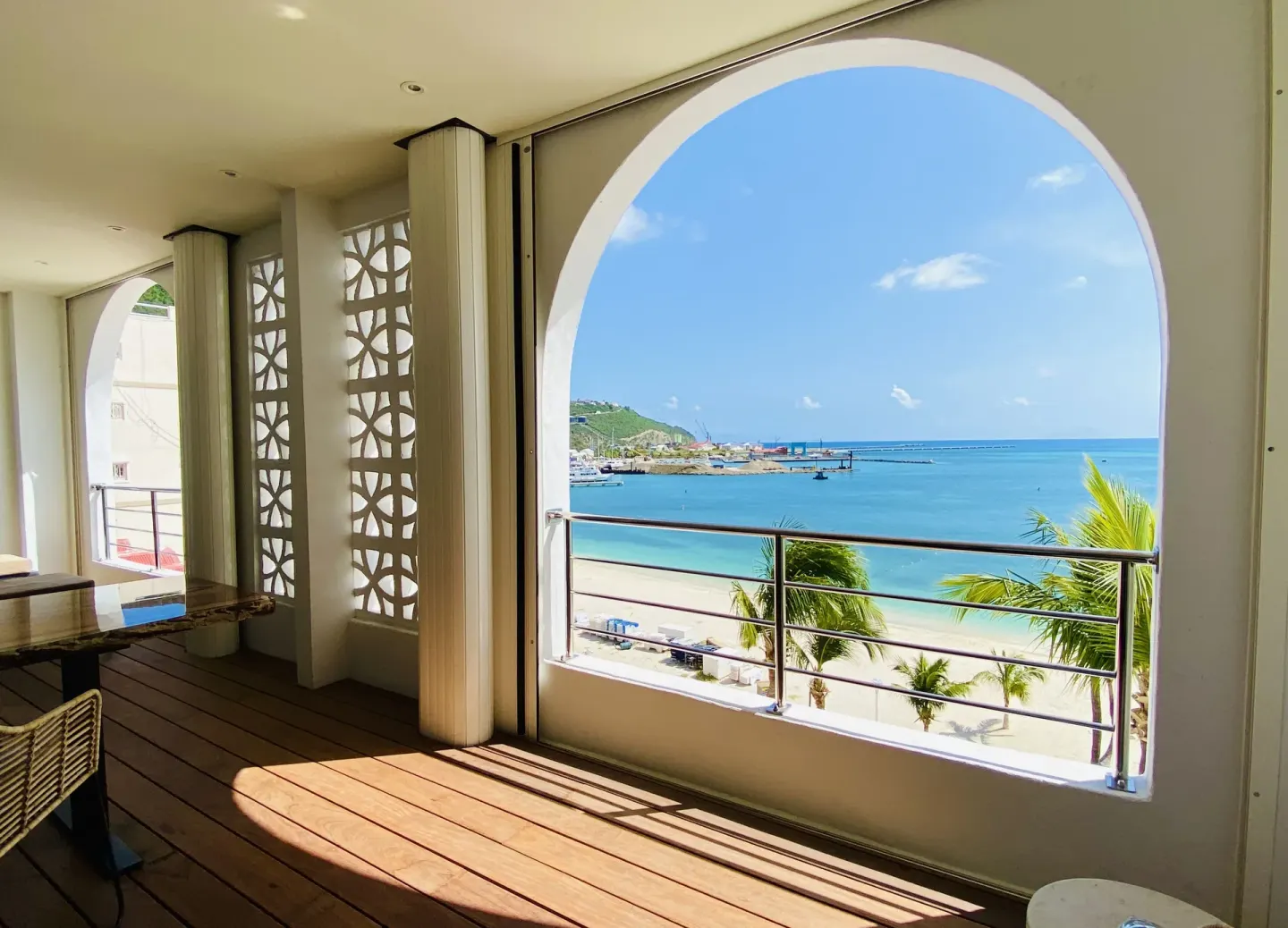 Covered balcony with arched beach view at Holland House Beach Hotel.