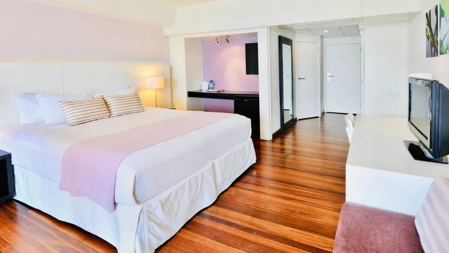 Deluxe Beach View king room with wood floors and seating at Holland House Beach Hotel.