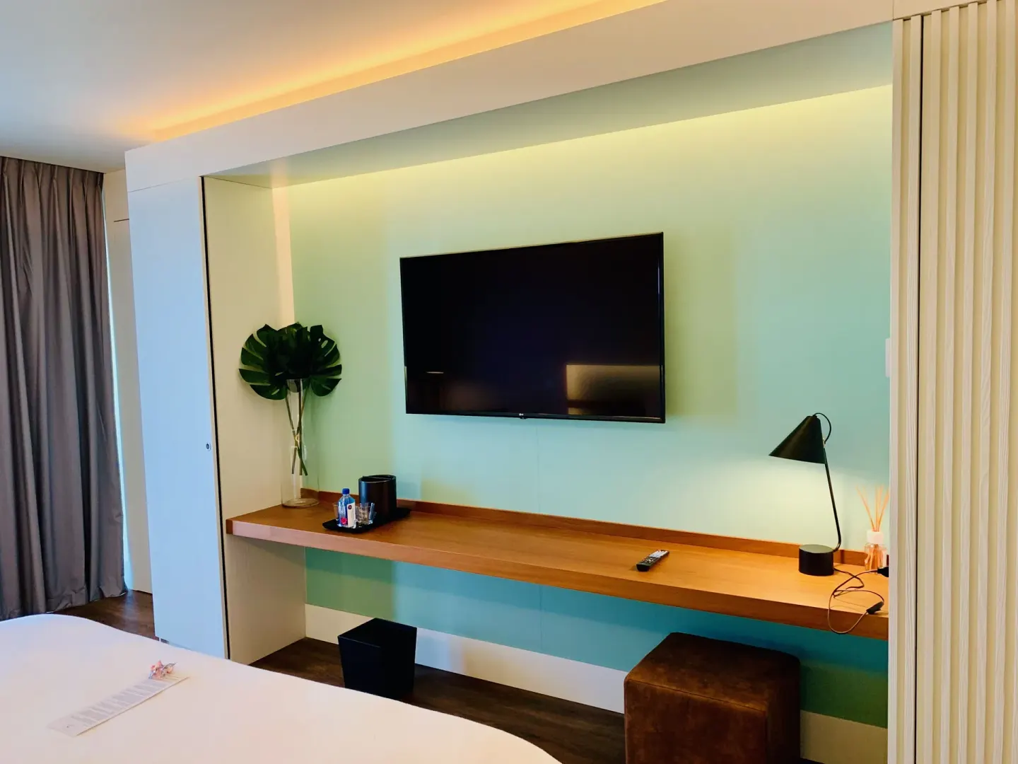 Executive Suite City View desk with TV, lamp and minibar setup at Holland House Beach Hotel.